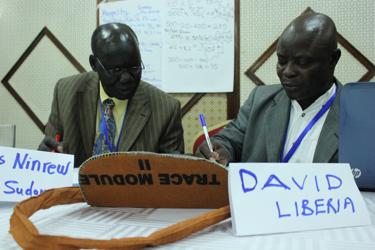 James Ninrew fra Sør-Sudan regner på betalinger til staten sammen med David Sackoh fra Liberia